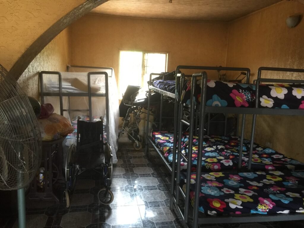 Children's dormitory with bunk beds and wheelchairs in a Nigerian orphanage, 2018