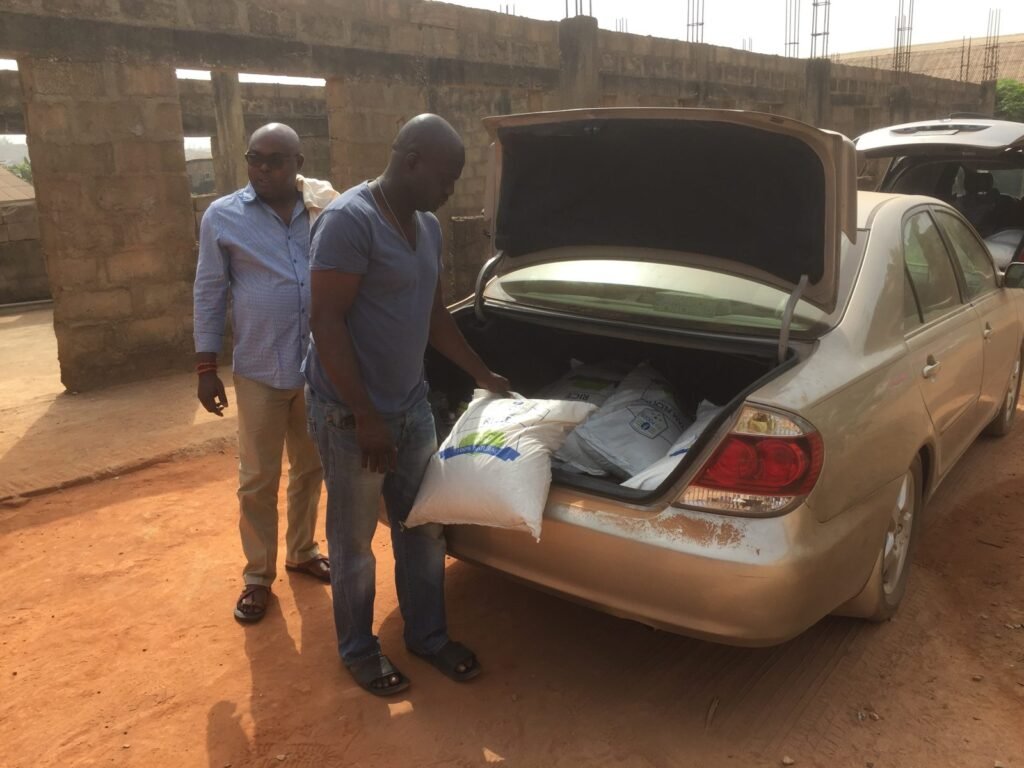 Volunteers unloading bags of food donations for orphans in Nigeria, 2018